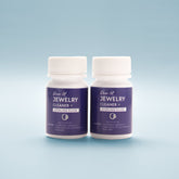 Close-up front view of two bottles of Jewellery Cleaner with blue label on a light blue background